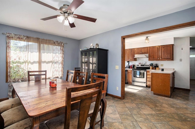 dining room with ceiling fan, baseboards, and stone finish flooring