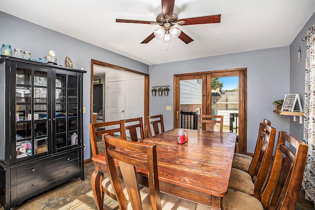 dining room featuring stone finish floor and ceiling fan