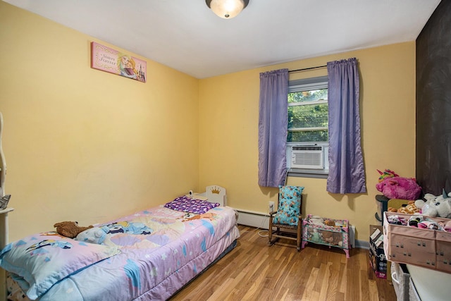 bedroom featuring baseboards, cooling unit, baseboard heating, and wood finished floors