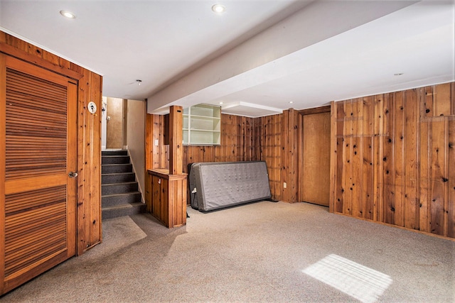 finished below grade area with stairway, wood walls, carpet, and recessed lighting