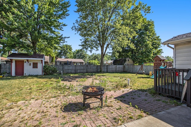 view of yard with a fenced backyard, a patio area, a playground, and a fire pit