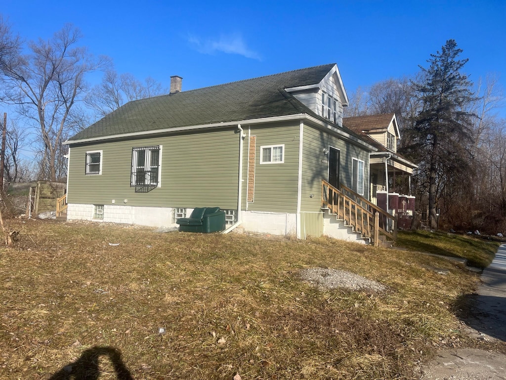 17333 Fenelon St, Hamtramck, MI 48212 - view of property exterior featuring a chimney and a shingled roof