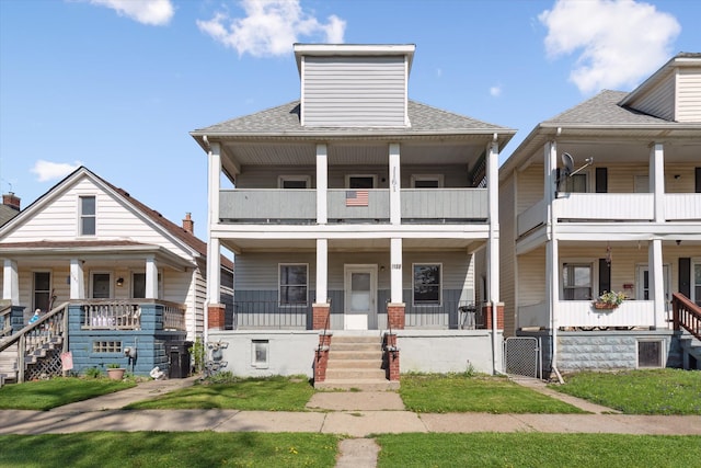 multi unit property featuring covered porch, a balcony, and roof with shingles