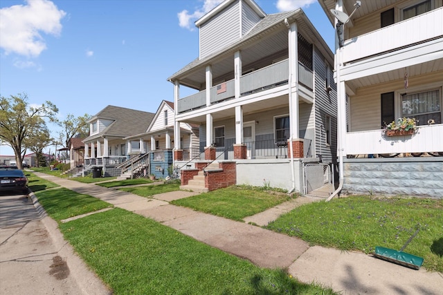 view of property with a balcony, covered porch, a residential view, and a gate