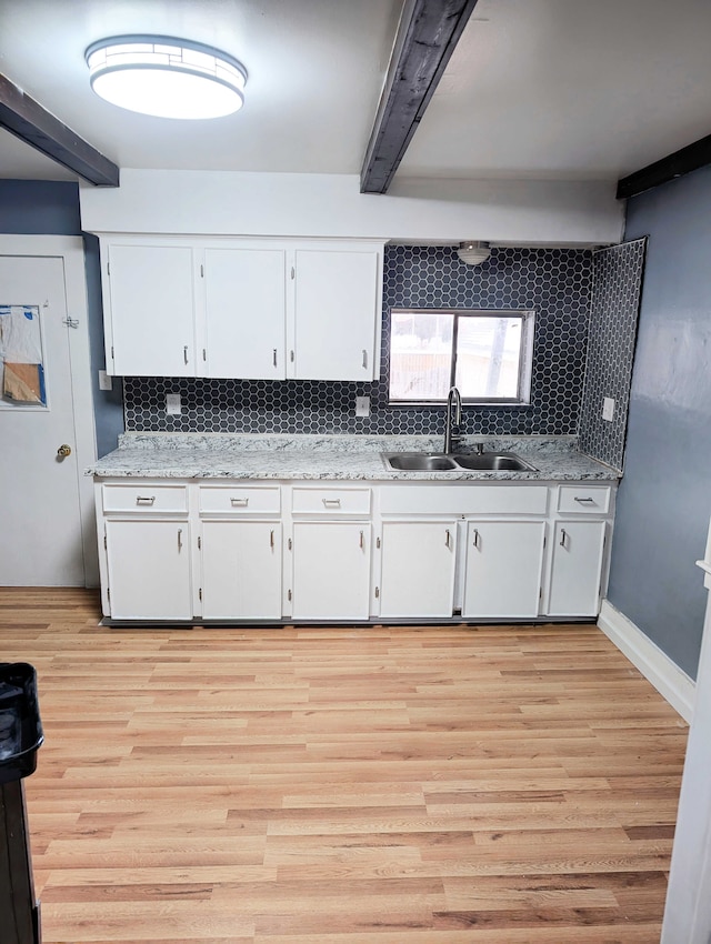 kitchen with white cabinetry, tasteful backsplash, and a sink