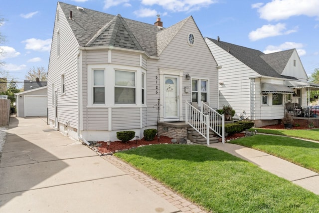 5125 Curtis St, Dearborn, MI 48126 - view of front facade with an outbuilding, a shingled roof, a front yard, and a garage