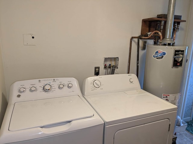 washroom with washing machine and clothes dryer and water heater