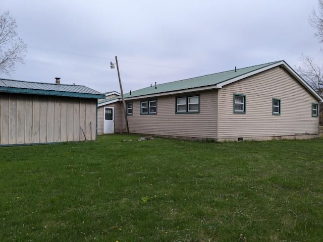 rear view of property with a lawn and crawl space