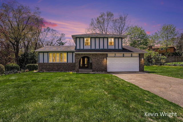 view of front of home featuring a yard, driveway, brick siding, and french doors