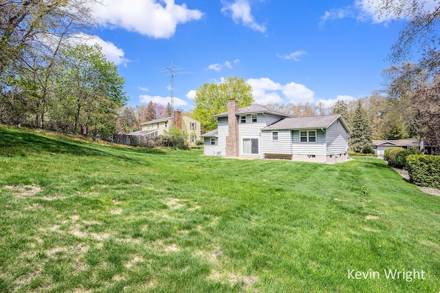 rear view of house featuring a yard, a chimney, and crawl space
