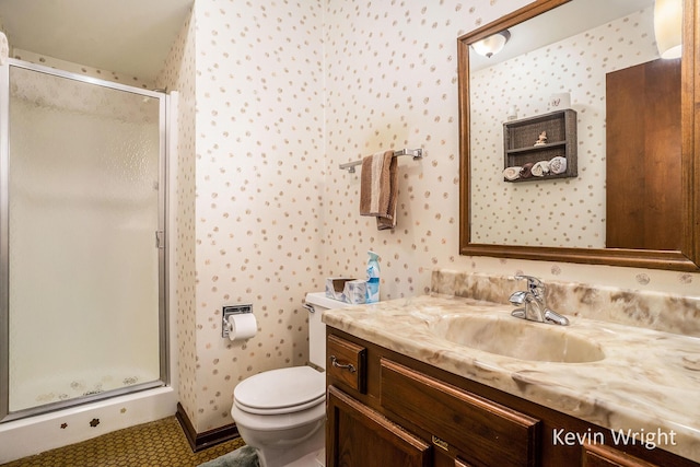 bathroom featuring wallpapered walls, toilet, a stall shower, and vanity