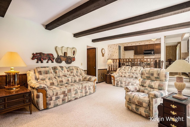 carpeted living area featuring beamed ceiling and a wainscoted wall