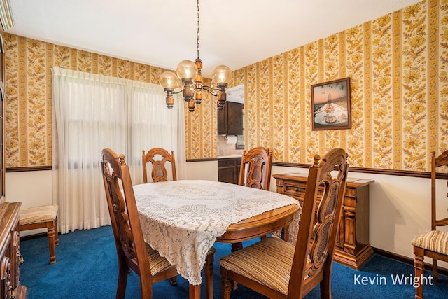 dining space featuring dark colored carpet, a chandelier, and wallpapered walls