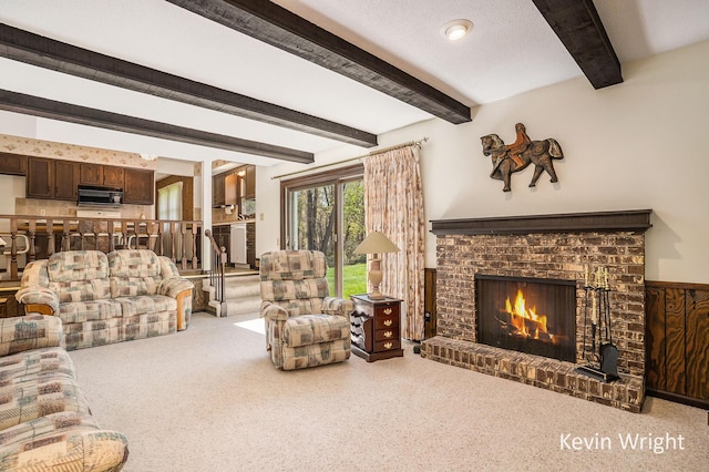 living area with a fireplace, beamed ceiling, and carpet floors