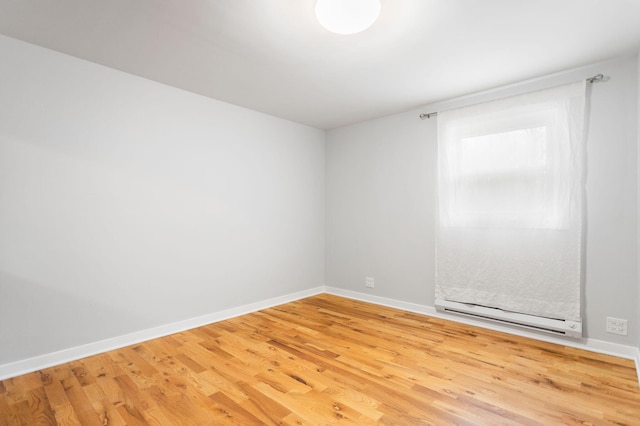empty room with baseboards and light wood-type flooring