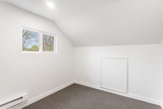 additional living space featuring vaulted ceiling, dark colored carpet, baseboards, and baseboard heating