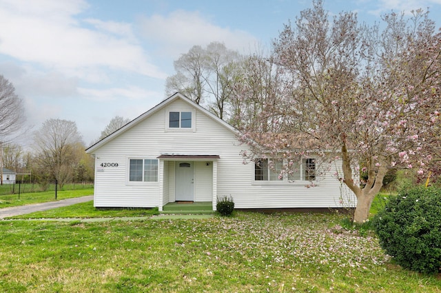 bungalow-style house featuring a front lawn