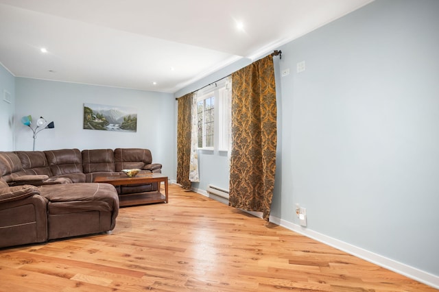 living area featuring a baseboard heating unit, recessed lighting, baseboards, and light wood-type flooring
