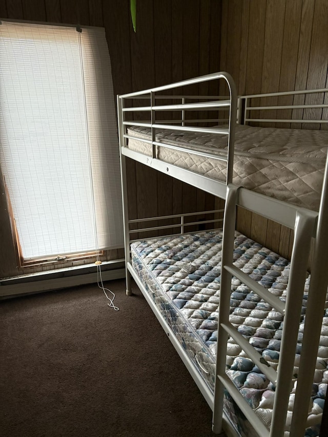 carpeted bedroom with wood walls
