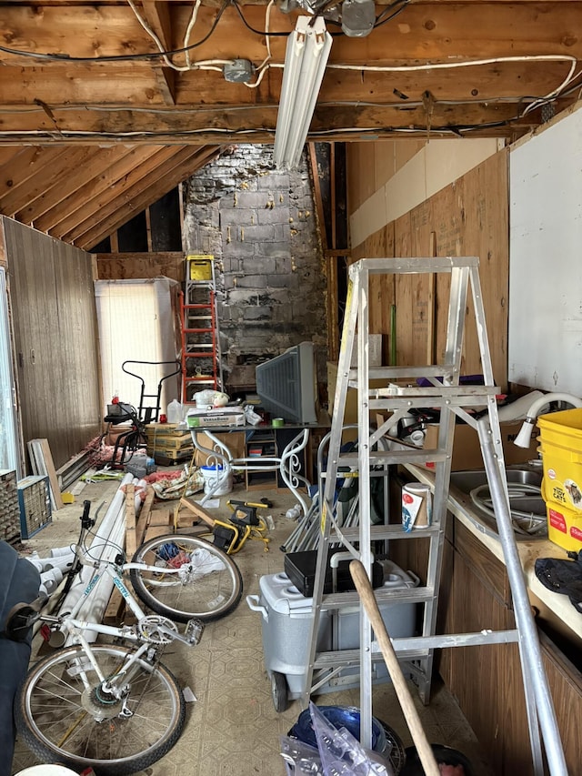 miscellaneous room featuring wooden walls and vaulted ceiling with beams