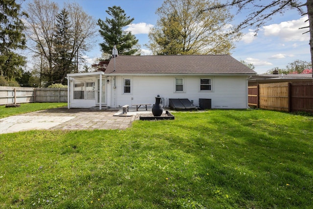 rear view of house with cooling unit, a patio, a lawn, and a fenced backyard