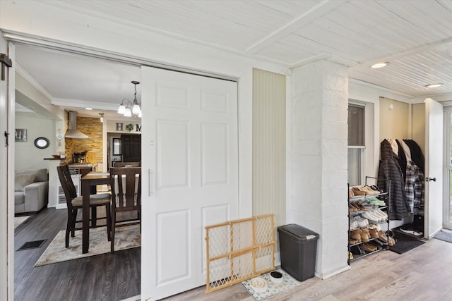 interior space featuring ornamental molding, a notable chandelier, visible vents, and wood finished floors