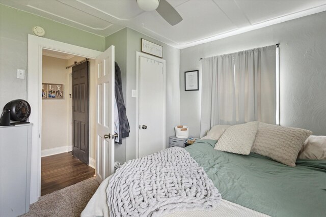 bedroom with ceiling fan, baseboards, carpet floors, and wood finished floors