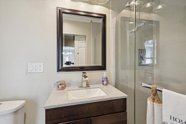 bathroom with toilet, a shower with door, and vanity