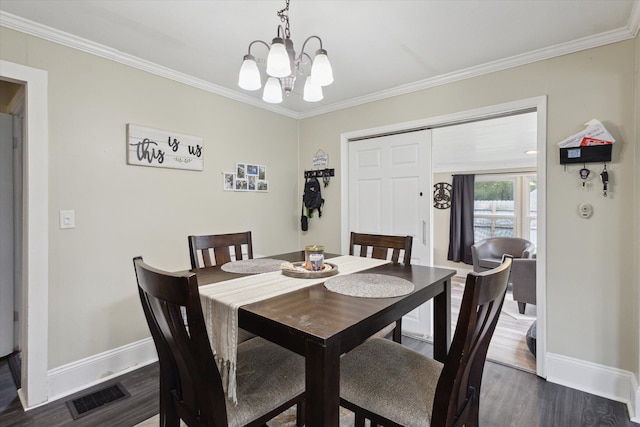 dining space featuring a chandelier, crown molding, visible vents, and baseboards