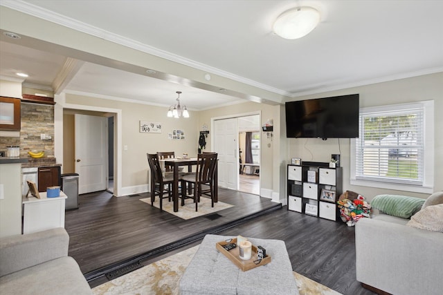 living room with crown molding, an inviting chandelier, baseboards, and dark wood-style floors