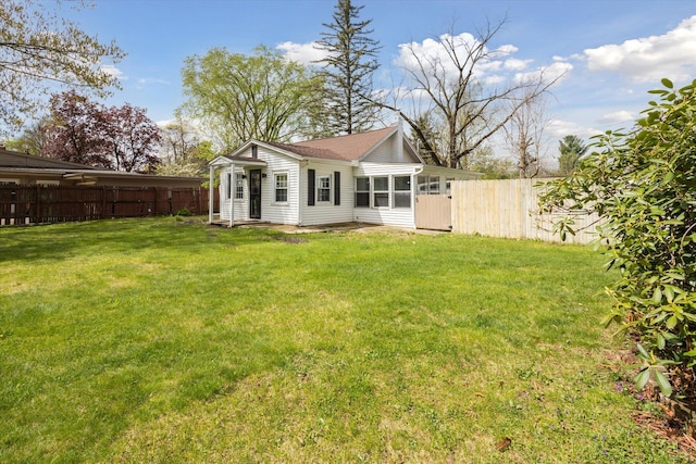 back of house featuring a yard and fence