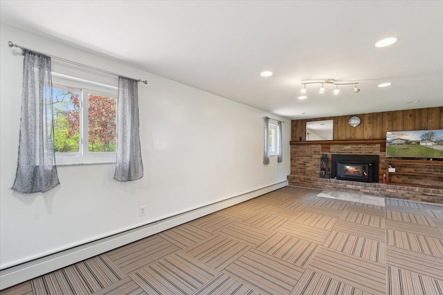 12441 Ray Rd, Ortonville, MI 48462 - unfurnished living room featuring a baseboard radiator, healthy amount of natural light, wooden walls, a fireplace, and recessed lighting