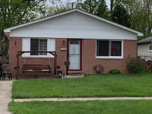 bungalow featuring brick siding and a front yard