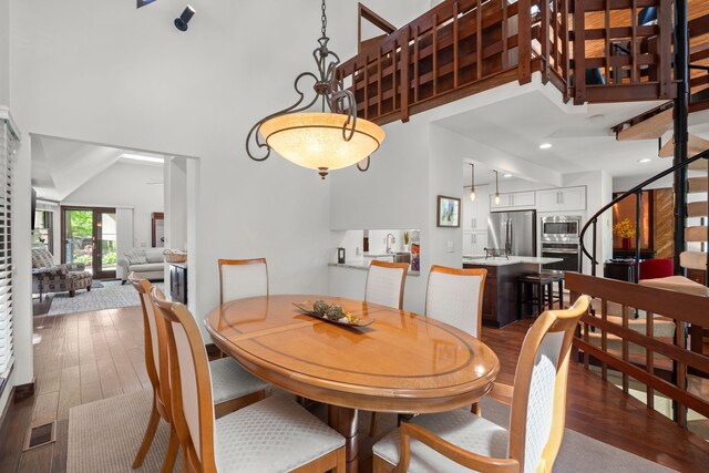 4943 Canyon Oaks Dr, Brighton, MI 48114 - dining room with a towering ceiling, wood finished floors, and stairs