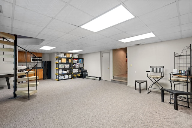 4943 Canyon Oaks Dr, Brighton, MI 48114 - finished basement with freestanding refrigerator, stairs, light colored carpet, a paneled ceiling, and a baseboard heating unit
