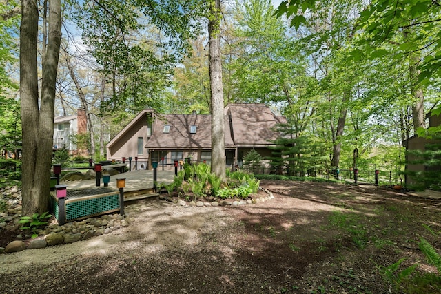 4943 Canyon Oaks Dr, Brighton, MI 48114 - back of property featuring a wooden deck and a shingled roof
