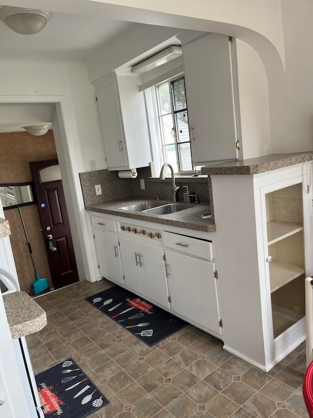 32230 5 Mile Rd, Livonia, MI 48154 - kitchen with dark countertops, white cabinetry, decorative backsplash, and a sink