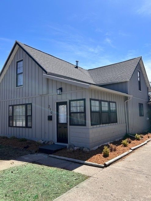 modern farmhouse style home with board and batten siding and roof with shingles