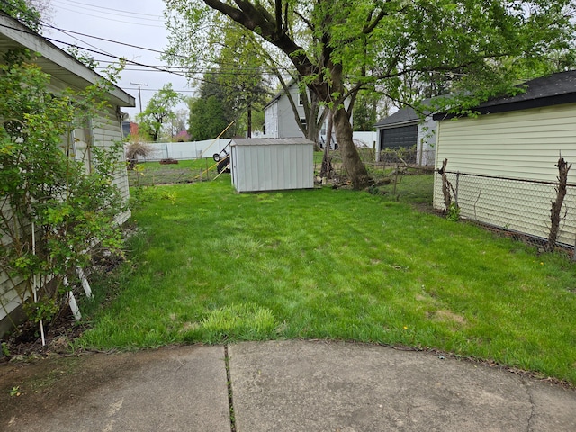view of yard with a storage shed, an outbuilding, and a fenced backyard