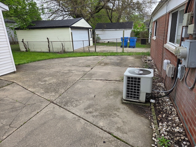 view of patio / terrace with central air condition unit, a garage, fence, and an outdoor structure