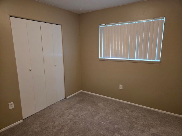 unfurnished bedroom with baseboards, a closet, and carpet floors