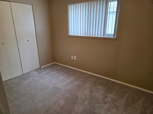 unfurnished bedroom featuring baseboards, a closet, and carpet floors