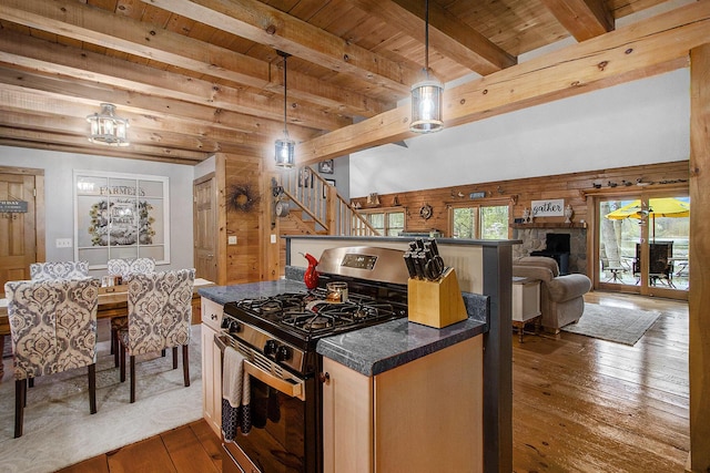 kitchen with dark countertops, dark wood finished floors, gas range, beamed ceiling, and wooden ceiling
