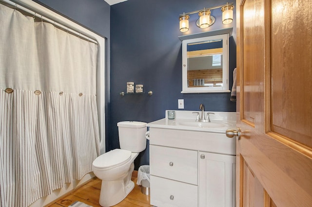 full bath featuring toilet, curtained shower, wood finished floors, and vanity