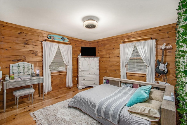 bedroom with wood walls and wood finished floors