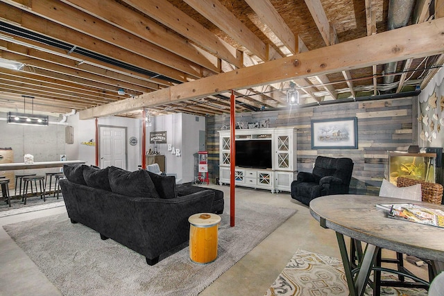 living area featuring wood walls and concrete flooring