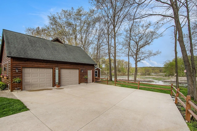 view of home's exterior featuring a shingled roof, faux log siding, and a garage