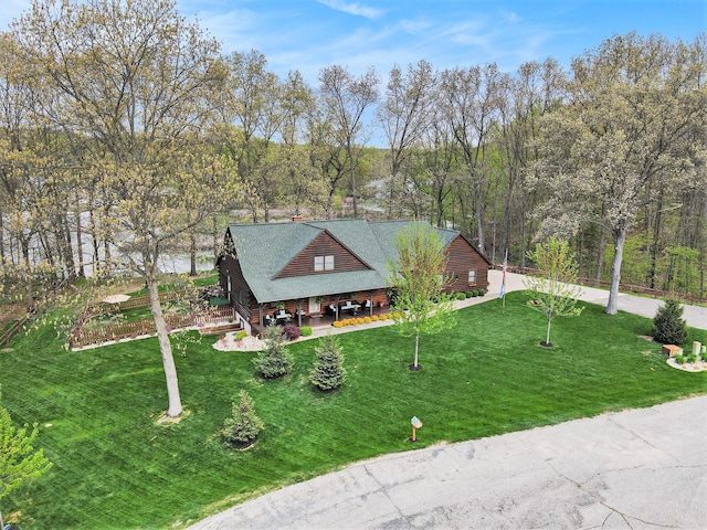 view of front of home featuring a shingled roof and a front yard