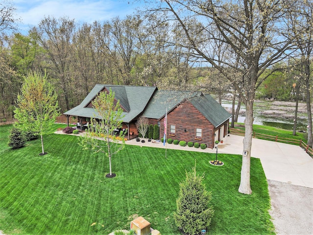 view of front of property featuring a garage, a front yard, a shingled roof, and driveway