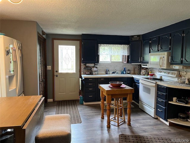 4564 Wildwood Rd, Alger, MI 48610 - kitchen featuring white appliances, light countertops, backsplash, wood finished floors, and a sink